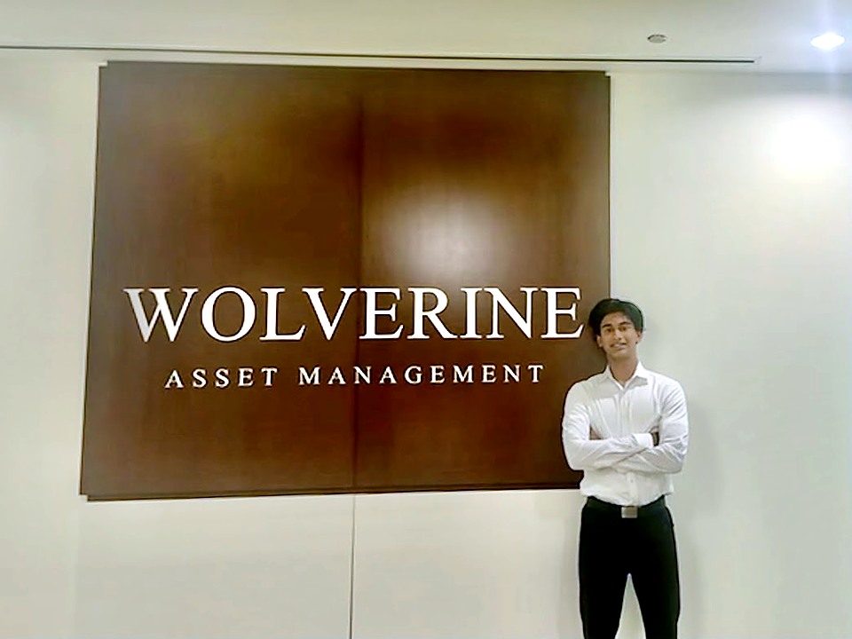 Gabriel Olasa in front of the Wolverine sign at their Chicago office