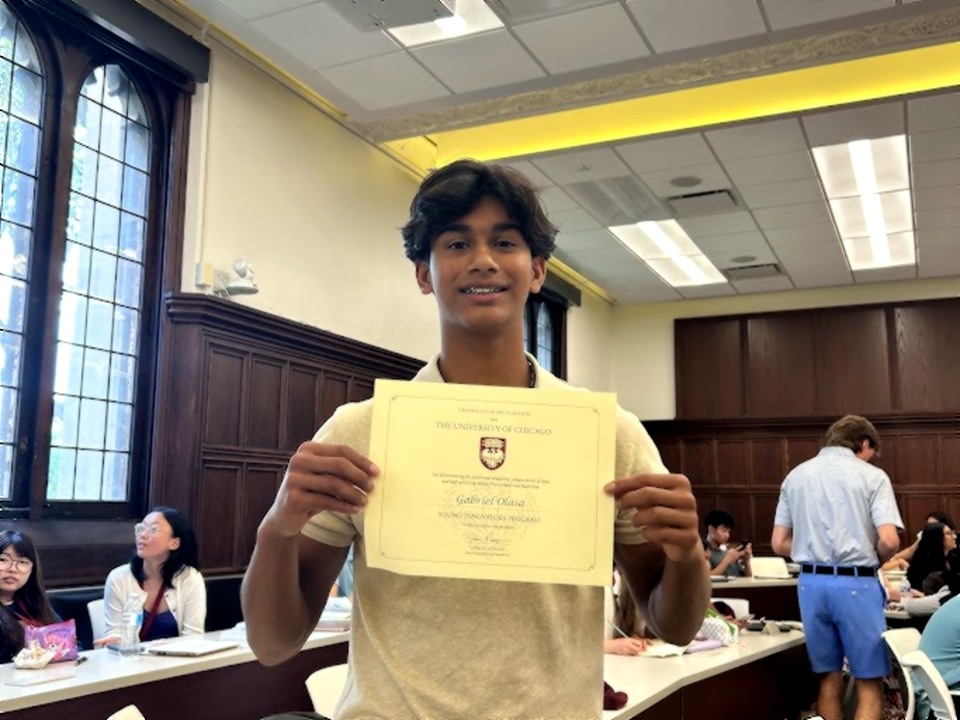 Gabriel Olasa holding his completion certificate for the University of Chicago's Young Innovators Program